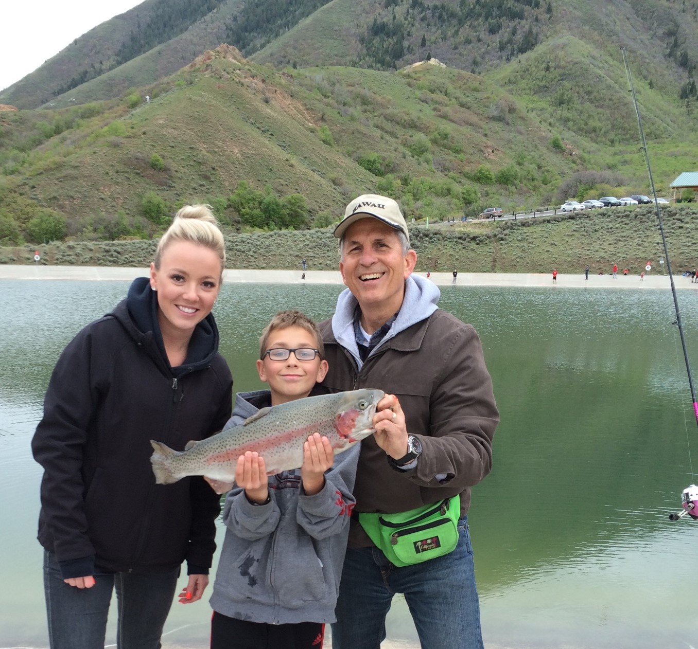 boy and 2 adults showing off a caught fish